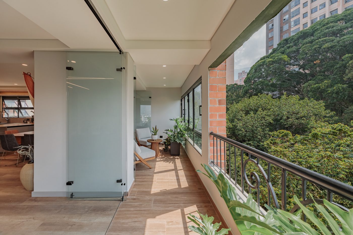 Balcón con piso de madera y vista a los árboles