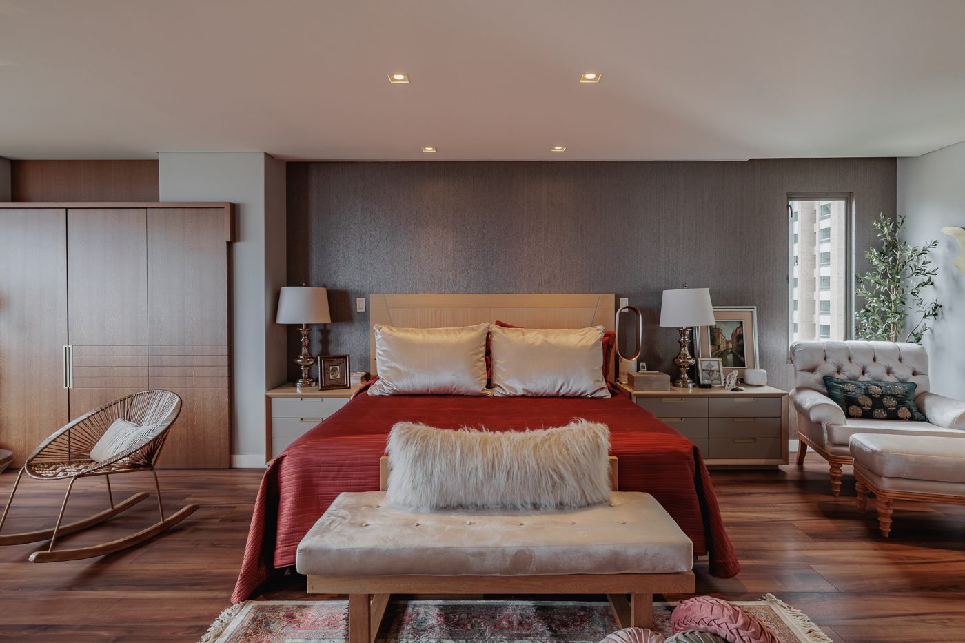 Habitación principal con cabecero en madera y ventanal